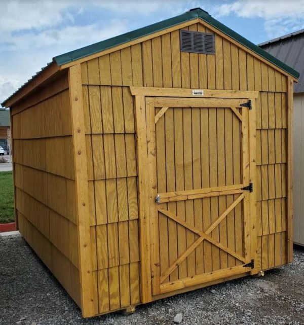 8x12 economy utility, standard 6ft 3in walls, hunter green metal roof, pressure treated T1-11 water sealed siding shake style, 4' single barn door, wood floor, 60lb snow load. As is - no warranty.