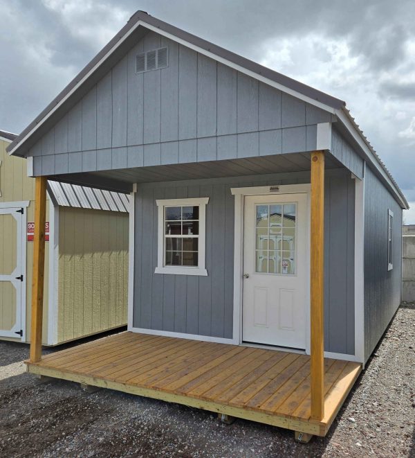 12x28 playhouse utility shed, charcoal metal roof, 7/12 roof pitch, 6in eave overhang front/back, playhouse package, 6ft porch, three 2x3 windows, 9 lite window house door, wooden floor, engineer certified.
