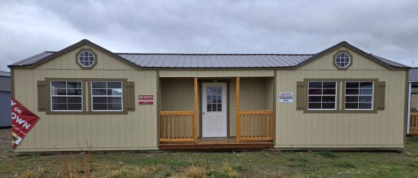 14x40 center porch utility shed, two gable dormers with two octagon windows, four 3x3 windows with shutters, four 3x3 windows, 8ft tall walls, burnished slate metal roof, crewel tan walls, thatch brown trim, 60lb snow load, engineer certified.