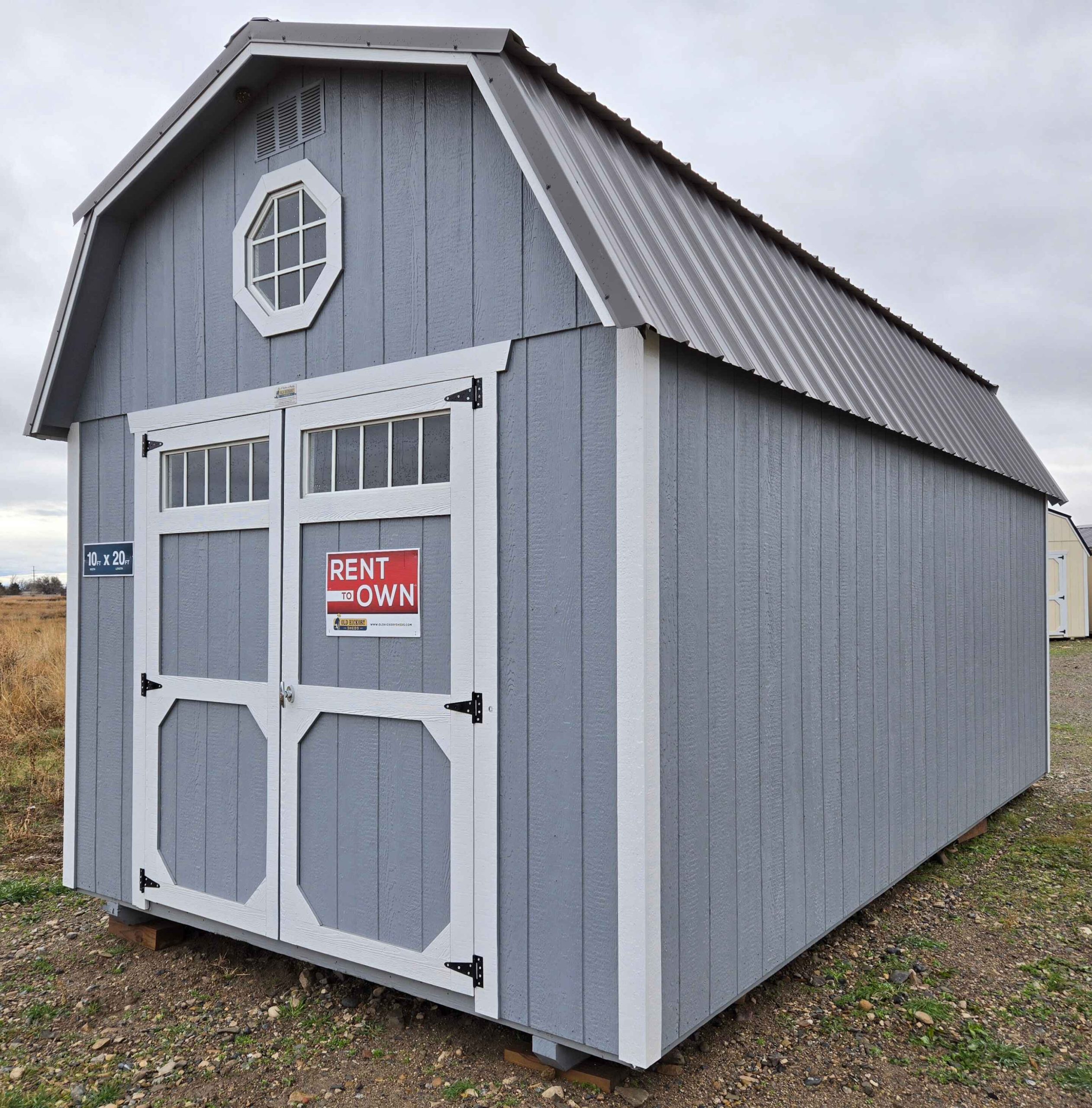 10x20 lofted barn shed, 6 inch roof overhang front & back, charcoal metal roof, steely gray walls, barn white trim, 7ft walls, two 4ft lofts, octagon window in front loft, double barn doors with windows, 10ft 3-tier shelving, wooden floor, 60lb snow load, engineer certified.