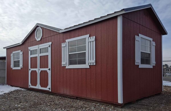 12x28 side gable utility, black metal roof, rustic red walls, barn white trim, 8ft tall walls, four 3x3 windows with shutters, octagon window, double barn doors with windows, wood floor, 60lb snow load, engineer certified.