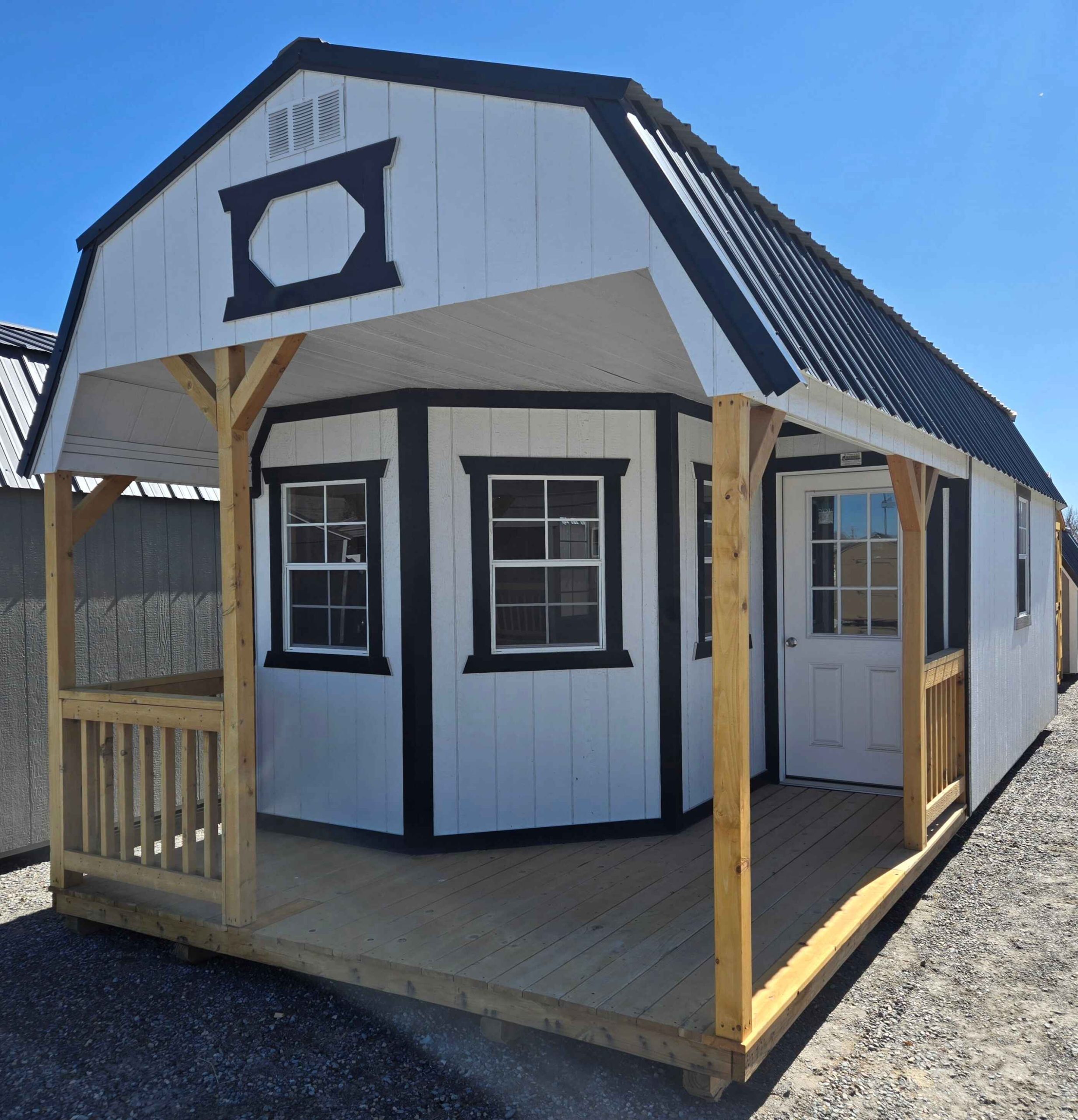 12x28 deluxe playhouse lofted barn, black metal roof, smart panel siding barn white color, tricorn black trim, wrap around porch on end, five 2x3 windows, 9-lite house door, 12ft of loft, wood floor, 60lb snow load, engineer certified.